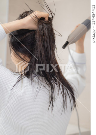 ドライヤーで髪の毛を乾かす若い女性 ドライヤーで髪の毛を乾かす若い女性 134484413