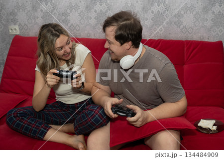 Couple Enjoys Playful Game Night, Couple Shares Laughter During Casual Game Evening At Home Couple Enjoys Playful Game Night, Couple Shares Laughter During Casual Game Evening At Home 134484909