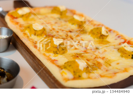 Rectangular Pizza with Sweet Pumpkin Topping and Cheese on a Wooden Board 134484940