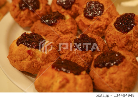 Baked Scones Topped with Berry Jam Served on a Plate under Bright Lighting Baked Scones Topped with Berry Jam Served on a Plate under Bright Lighting 134484949
