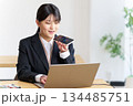 パソコン作業をしながら音声AIを使う女性社員 134485751