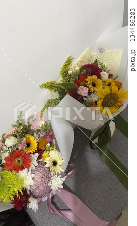 Bouquet of fresh flowers with vibrant colorful petals and lush green leaves, carefully arranged to highlight natural beauty, soft textures, and harmonious elegance in close-up detail Bouquet of fresh flowers with vibrant colorful petals and lush green leaves, carefully arranged to highlight natural beauty, soft textures, and harmonious elegance in close-up detail 134486283