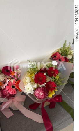 Bouquet of fresh flowers with vibrant colorful petals and lush green leaves, carefully arranged to highlight natural beauty, soft textures, and harmonious elegance in close-up detail Bouquet of fresh flowers with vibrant colorful petals and lush green leaves, carefully arranged to highlight natural beauty, soft textures, and harmonious elegance in close-up detail 134486284