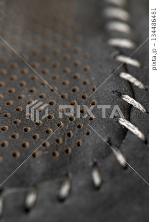 dark smooth leather for shoe production , a large number of equal holes in natural leather for shoe production 134486481