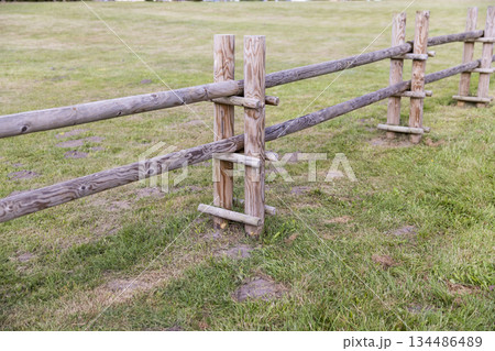 part of a new wooden fence made of logs and roundwood in rural areas, primitive fencing against large animals in rural areas during the summer season, cloudy weather part of a new wooden fence made of logs and roundwood in rural areas, primitive fencing against large animals in rural areas during the summer season, cloudy weather 134486489