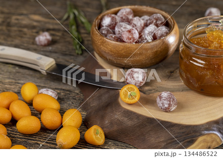 orange jam made from oranges and citrus fruits and dried in sugar syrup, whole fruits in white powder, a glass jar with sweet orange jam is on the table orange jam made from oranges and citrus fruits and dried in sugar syrup, whole fruits in white powder, a glass jar with sweet orange jam is on the table 134486522