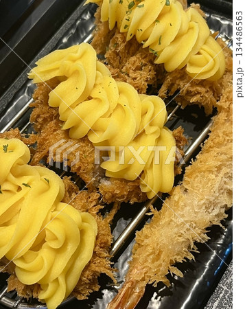 Crispy tonkatsu, a Japanese-style breaded and deep-fried pork cutlet, served with shredded cabbage and drizzled with savory sauce. A delightful balance of crunchy texture and juicy meat. 134486563
