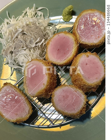 Crispy tonkatsu, a Japanese-style breaded and deep-fried pork cutlet, served with shredded cabbage and drizzled with savory sauce. A delightful balance of crunchy texture and juicy meat. 134486668