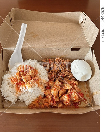 Nasi campur, a classic Indonesian dish featuring rice with an assortment of flavorful sides like fried chicken, sambal, vegetables, and tempeh. A vibrant, balanced meal celebrating Indonesian flavors. 134486766