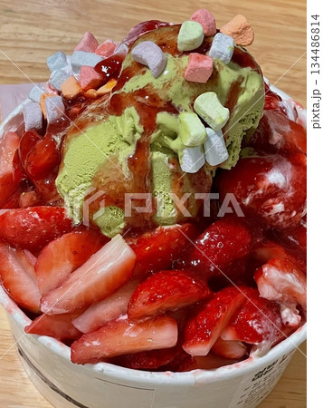 Refreshing bingsu, a Korean shaved ice dessert topped with sweet ingredients like red beans, fruits, and condensed milk. A perfect treat to cool down on hot days. Refreshing bingsu, a Korean shaved ice dessert topped with sweet ingredients like red beans, fruits, and condensed milk. A perfect treat to cool down on hot days. 134486814
