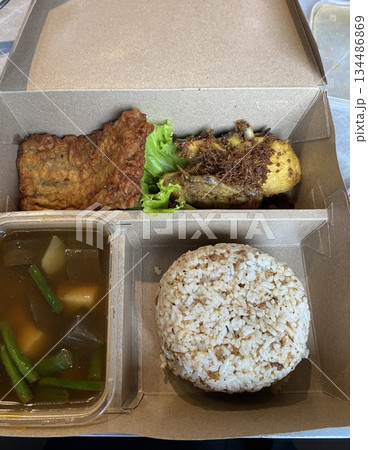 Nasi campur, a classic Indonesian dish featuring rice with an assortment of flavorful sides like fried chicken, sambal, vegetables, and tempeh. A vibrant, balanced meal celebrating Indonesian flavors. Nasi campur, a classic Indonesian dish featuring rice with an assortment of flavorful sides like fried chicken, sambal, vegetables, and tempeh. A vibrant, balanced meal celebrating Indonesian flavors. 134486869