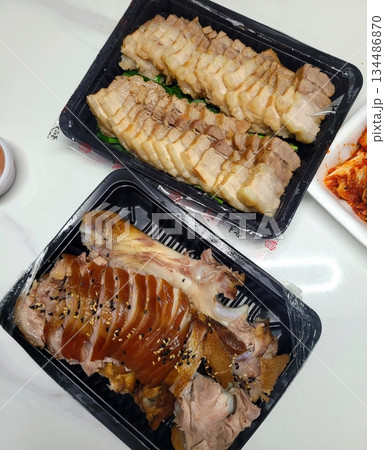 Jokbal, a Korean dish of braised pork hock, slow-cooked in a rich, savory sauce with soy, garlic, and spices. Tender and flavorful, it’s often served with lettuce wraps, garlic, and ssamjang 134486870