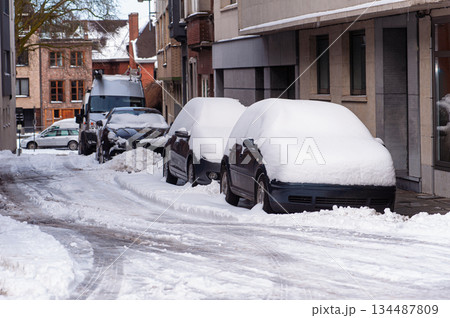 Snow Covered Cars Parked Along Snowy Urban Street With Buildings and Sidewalks Snow Covered Cars Parked Along Snowy Urban Street With Buildings and Sidewalks 134487809