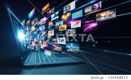 Digital display of various media streaming from open laptop at night highlighting technology and innovation 134488615