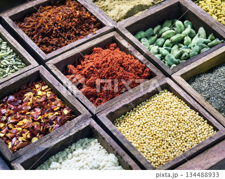 Various kinds of spices arranged in wooden boxes at a market for cooking and flavoring food 134488933
