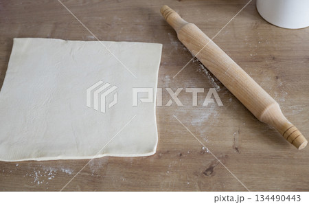 rolling pin and flour on wooden background. 134490443