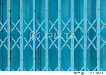 Blue expandable steel gate showing a traditional folding mechanism Blue expandable steel gate showing a traditional folding mechanism 134490641