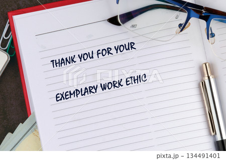 An open notebook showing a message that says Thank You For Your Exemplary Work Ethic. A pen and glasses sit on top of the notebook on a desk An open notebook showing a message that says Thank You For Your Exemplary Work Ethic. A pen and glasses sit on top of the notebook on a desk 134491401