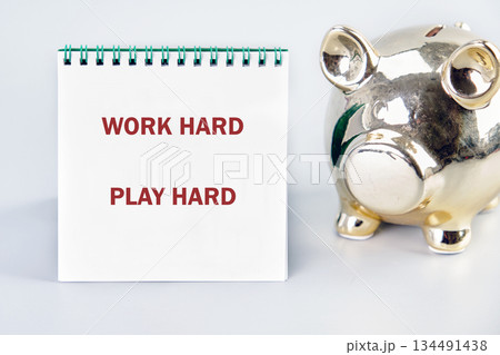 A notebook displays the words Work Hard Play Hard in red lettering 134491438