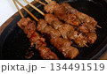 4k detailed chicken satay grilling on hot plate 134491519
