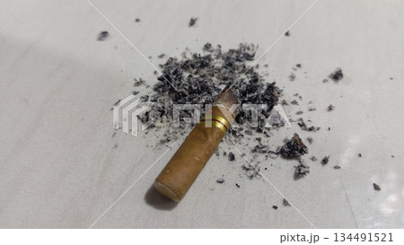 4k closeup cigarette butt with scattered ashes 134491521