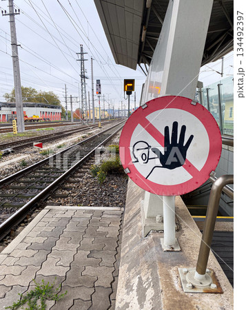 No entry warning sign with a hand icon on a railway station platform. 134492397