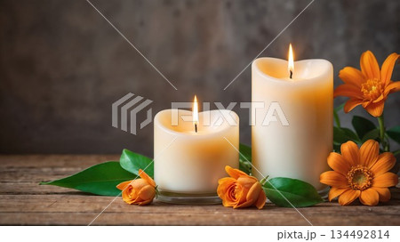 Warm candles illuminate orange flowers on rustic wood 134492814