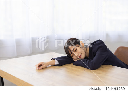 デスクに伏せて眠る若い日本人ビジネスウーマン デスクに伏せて眠る若い日本人ビジネスウーマン 134493980