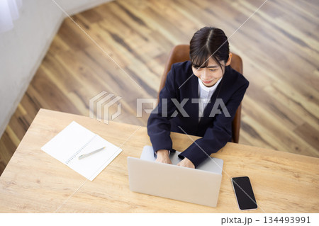 パソコンで仕事をする若いビジネスウーマン パソコンで仕事をする若いビジネスウーマン 134493991