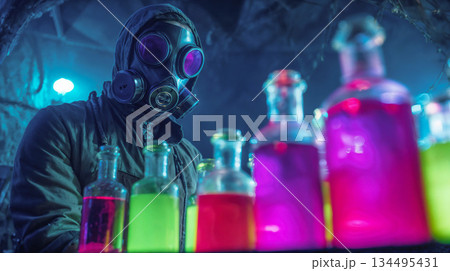 Person in gas mask examining glowing chemical bottles 134495431