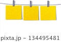 Three Bright Yellow Sticky Notes Hanging on Clothesline with Clips for Reminder, Planning, and Organization Concepts 134495481