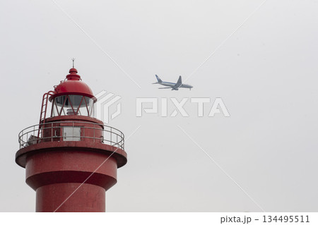 赤い小さな灯台と旅客機・若洲海浜公園 134495511
