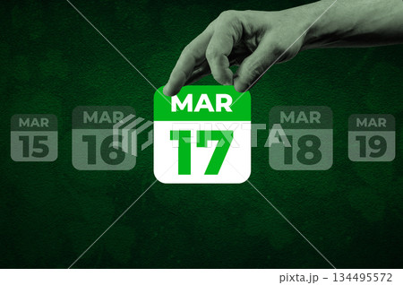 St Patrick day March 17th Calendar Page. Halftone collage of a hand holding a calendar page with the words March 17 134495572