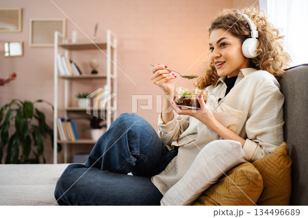 Young adult woman eating salad enjoying healthy lifestyle Young adult woman eating salad enjoying healthy lifestyle 134496689