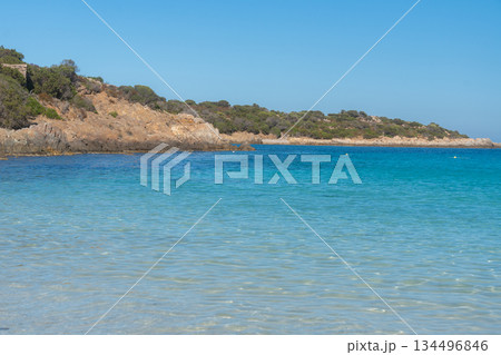 Calm shallow sea near rocky coastline with clear turquoise water. Natural summer seascape and peaceful atmosphere, La Maddalena, Italy 134496846