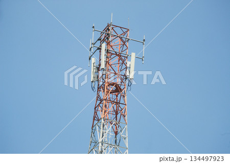 Telecommunication tower with multiple antennas and transmitters standing against a clear blue sky Telecommunication tower with multiple antennas and transmitters standing against a clear blue sky 134497923