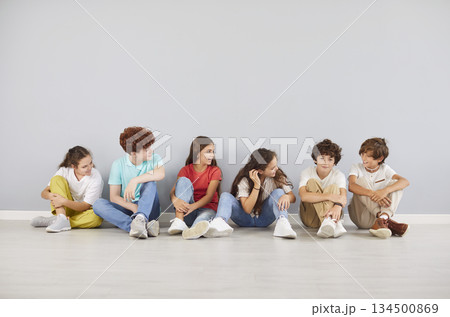 School children, young student friends and classmates girls and boys sitting together at wall School children, young student friends and classmates girls and boys sitting together at wall 134500869