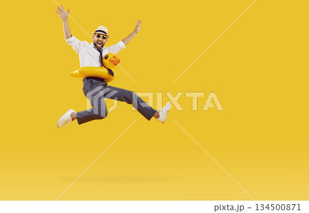Funny cheerful businessman with inflatable swimming circle having fun on orange background. 134500871