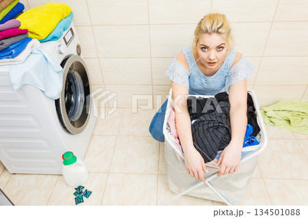 Unhappy girl with dirty clothes laundry. 134501088