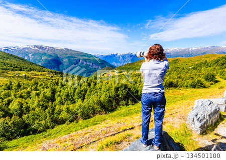 Tourist taking photo in norwegian nature 134501100
