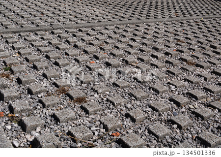 General view of permeable concrete pavers filled with gravel, with an outer covering for drainage and stability. A sustainable planning concept with modern paving solutions. 134501336