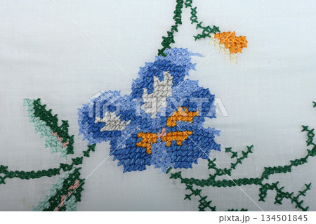 Vintage handmade floral cross-stitch embroidery and lace on white linen 134501845