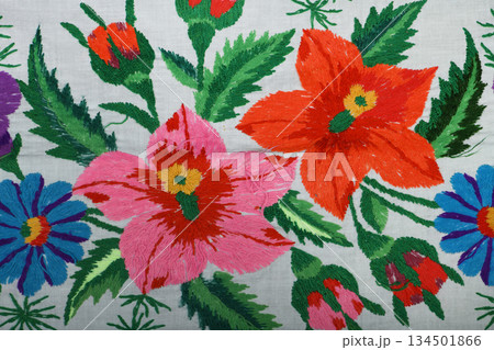 Vintage embroidery featuring pink and red flowers with green leaves Vintage embroidery featuring pink and red flowers with green leaves 134501866