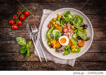 Tuna salad with tomatoes , olives , eggs and onion . Tuna salad with tomatoes , olives , eggs and onion . 134502206