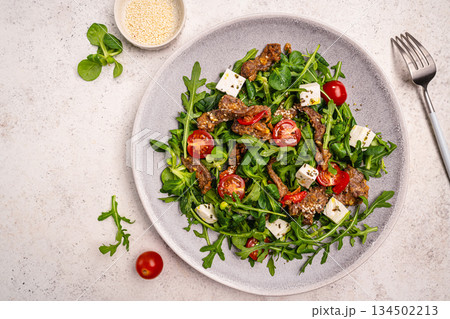 Warm beef meat salad with arugula Warm beef meat salad with arugula 134502213