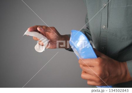 a man holding a shopping receipt and a packet a man holding a shopping receipt and a packet 134502843