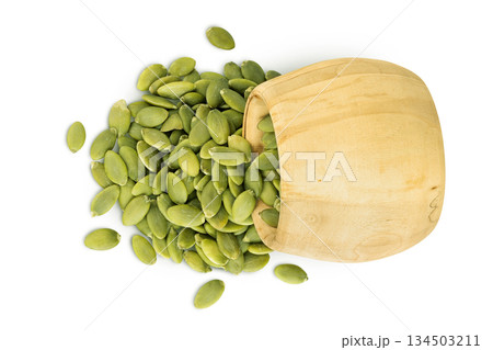 Peeled pumpkin seeds in wooden bowl isolated on white background. Top view. Flat lay 134503211