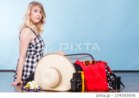 Young woman packing suitcase 134503656