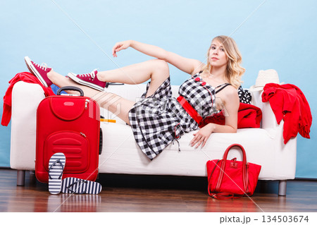 Woman relaxing after packing suitcase for vacation Woman relaxing after packing suitcase for vacation 134503674