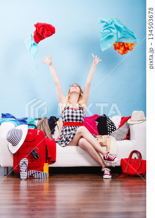 Woman throwing up clothes, clothing flying everywhere 134503678